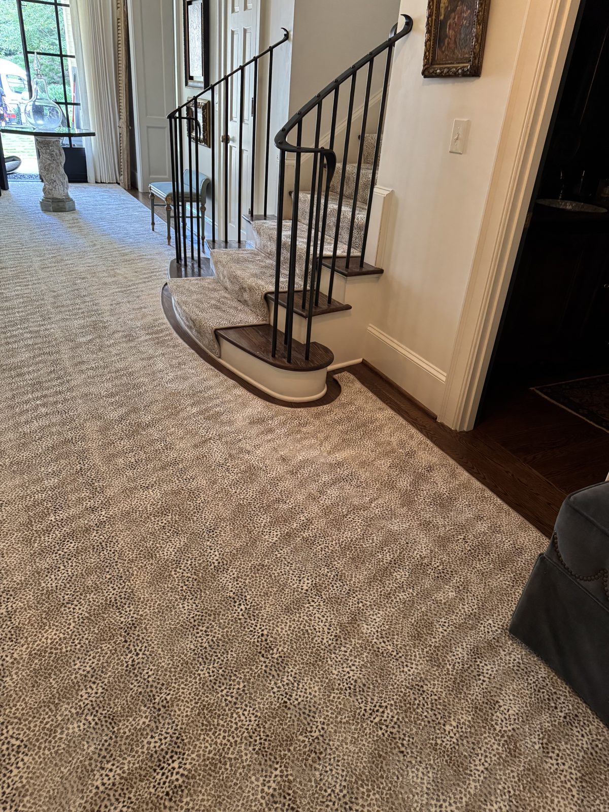 Antelope-print carpet custom-cut to fit a room with a curved staircase by Underfoot Design