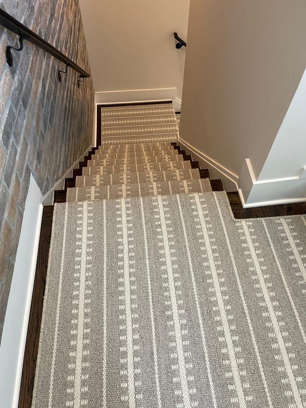 Subtle gray striped stair runner on hardwood stairs and landing