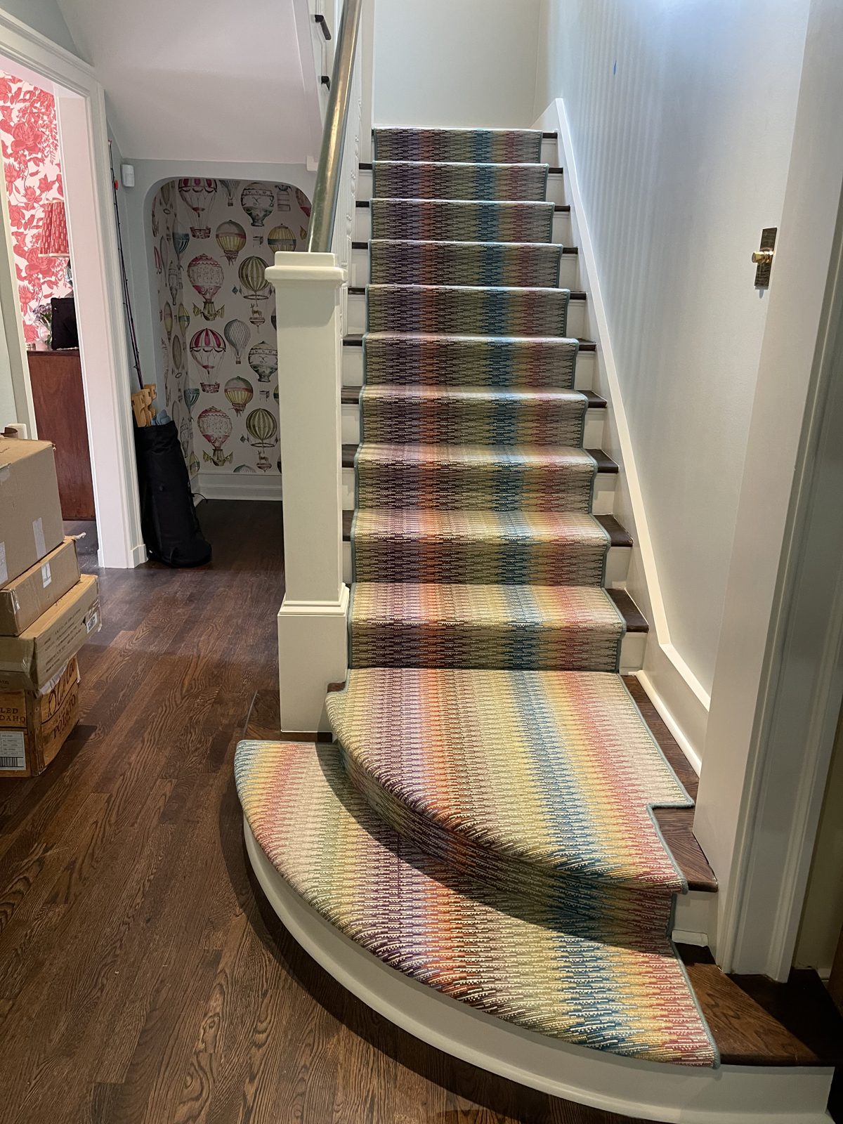 Colorful striped stair runner on a curved staircase